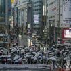 Umbrellas fill the famed Shibuya scramble crossing as people walk across the intersection in rain Monday, April 4, 2022, in Tokyo. (AP Photo/Kiichiro Sato)