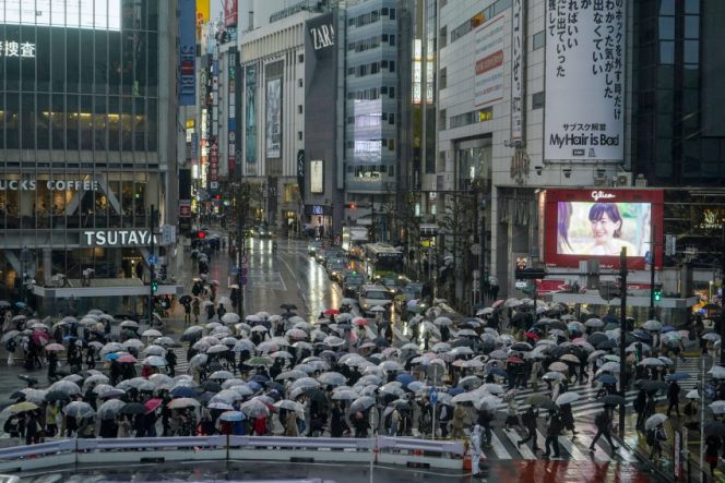
					Umbrellas fill the famed Shibuya scramble crossing as people walk across the intersection in rain Monday, April 4, 2022, in Tokyo. (AP Photo/Kiichiro Sato)